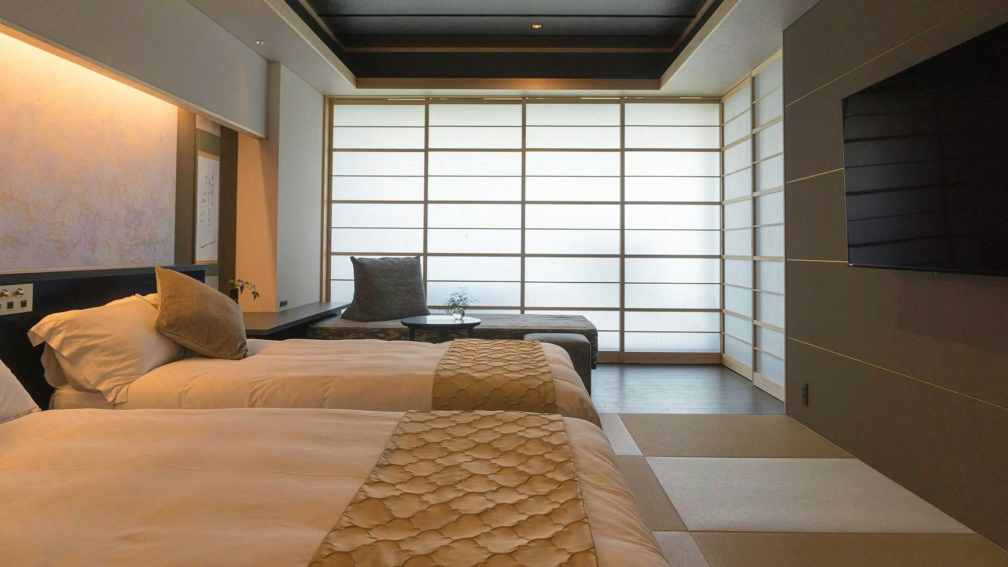 Ryoso Uminocho with this scene, where twin beds and a tatami sitting area share a bright sea-facing guest room.