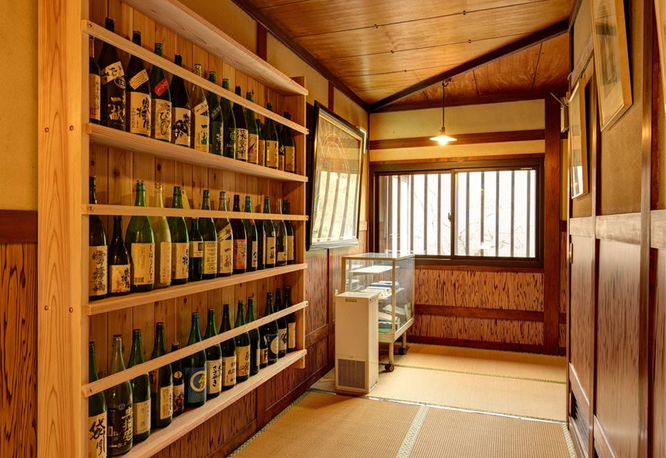 Shelves of sake bottles in a wooden interior.