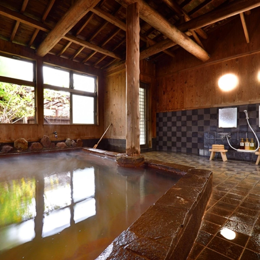 Indoor bath in a wood-beamed room.
