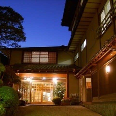 Shima Onsen Private Bath Inn Jyojukan with a lantern-lit facade and glass entrance at dusk.