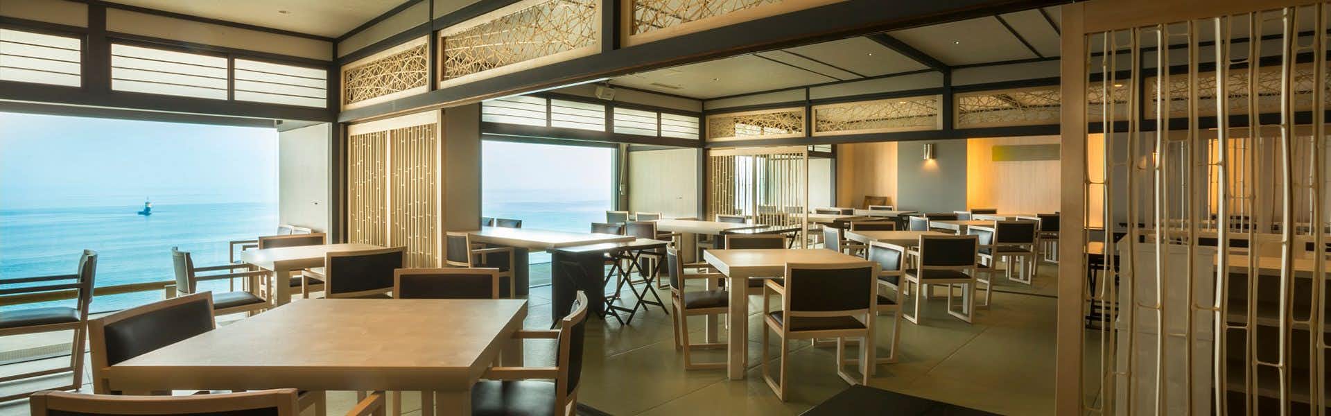 Ginpaso Inn with Spectacular Open-Air Bath with a modern dining room with pale tables and ocean windows.