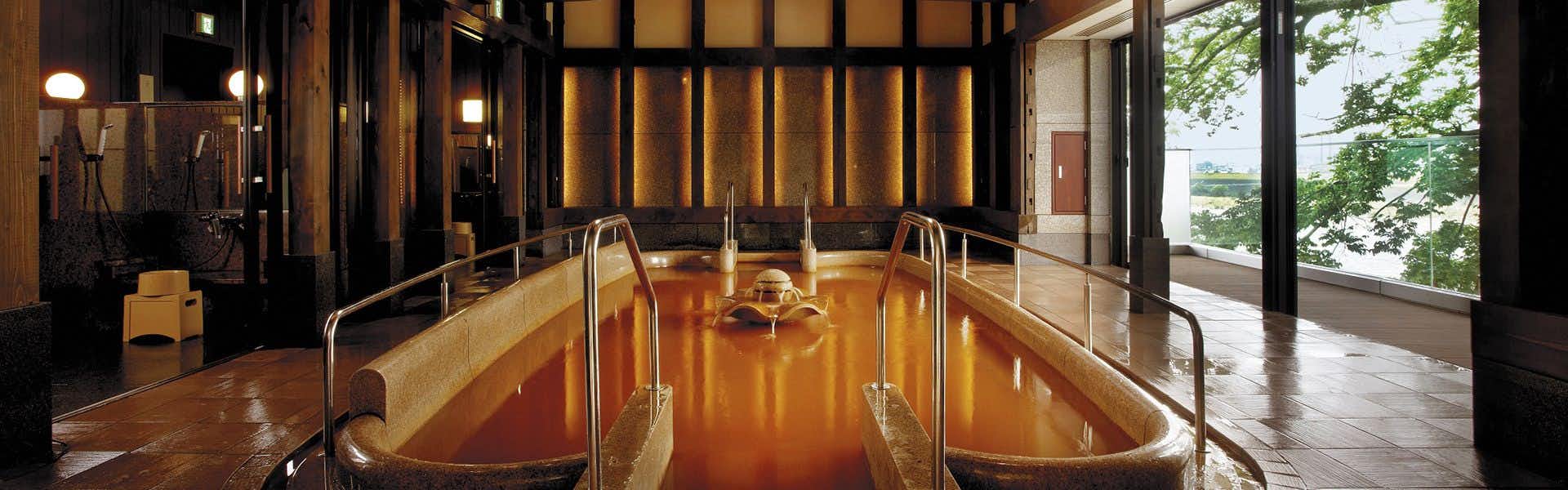 Juhachiro with a private timber bath glowing beside garden-facing windows.