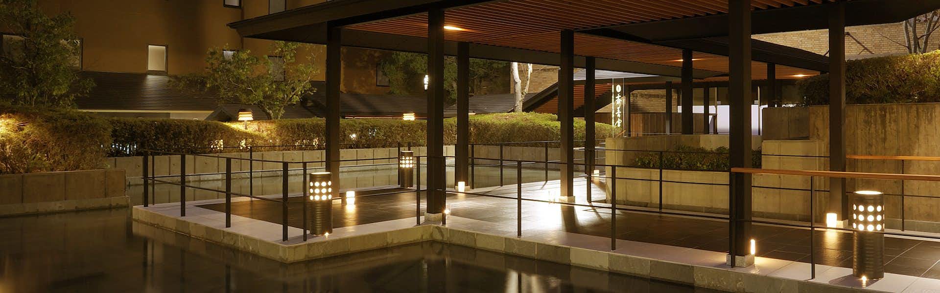 Saio-no-Miya: A Dream Inn of Imperial Romance Nestled in Ise with modern glass corridors reflecting warm garden lights.