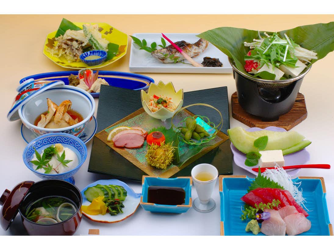 Mountain Lodge Nagisa with a Japanese dinner arranged across colorful ceramic dishes.