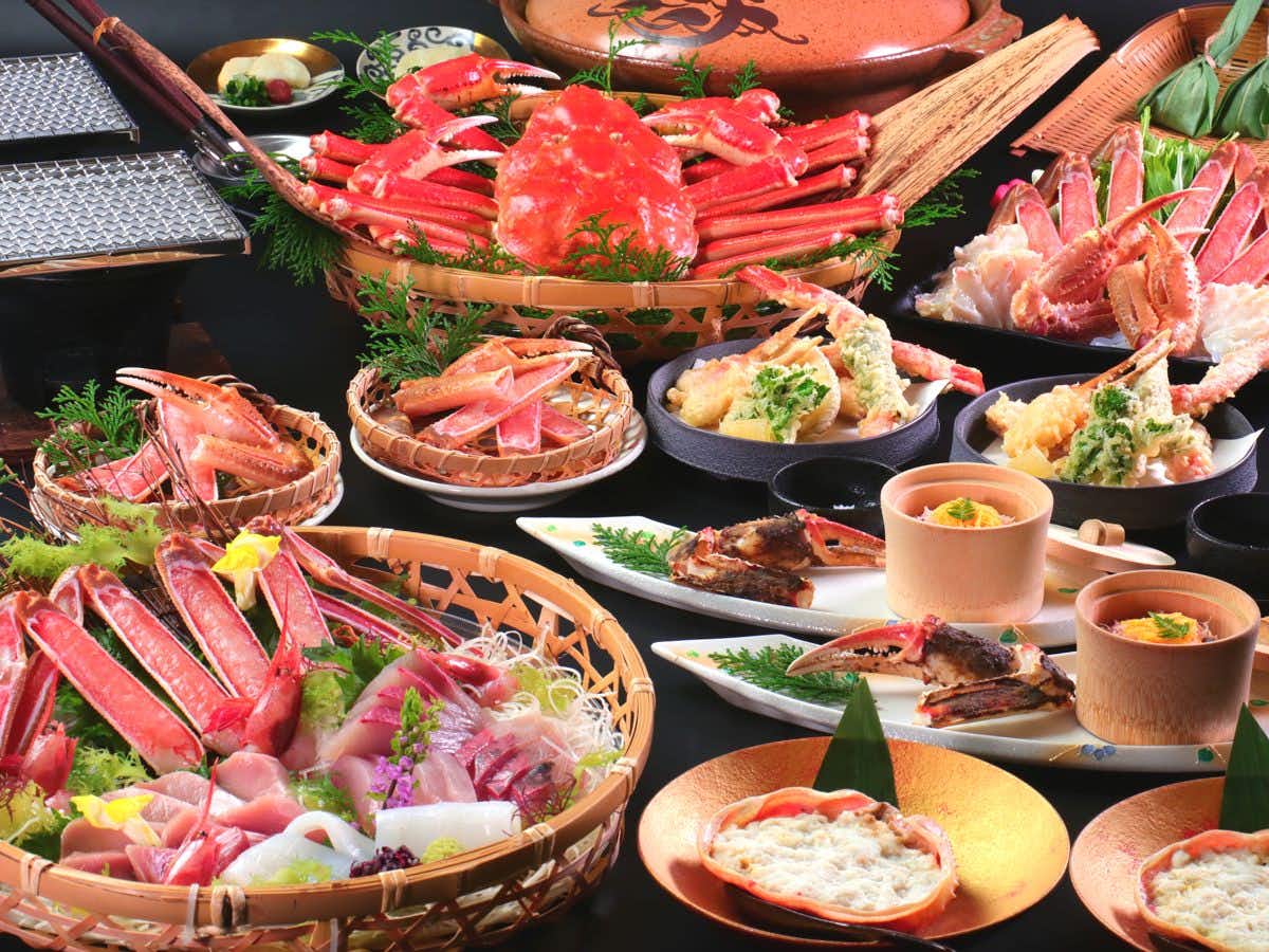 Yuhigaura Onsen Ryokan Katou with a lavish crab banquet arranged across baskets and lacquered dishes.