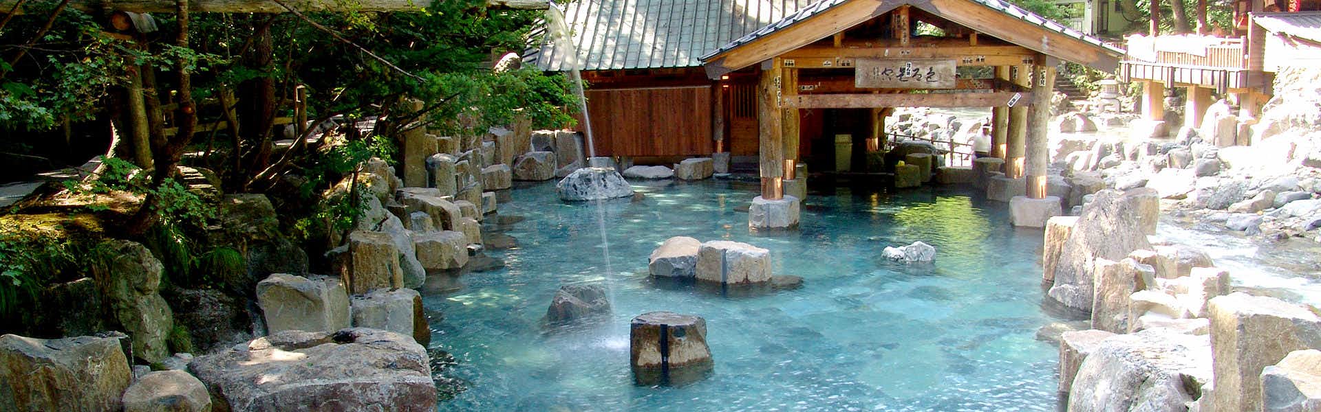 Wangquan Pavilion with a riverside outdoor bath surrounded by stone and timber buildings.