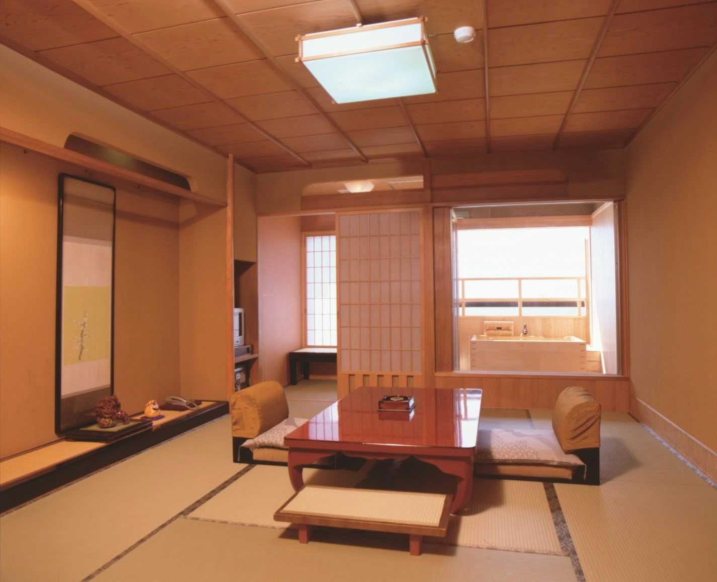 Tatami Inn Yunohama-tei with a traditional tatami guest room beside wide coastal windows.