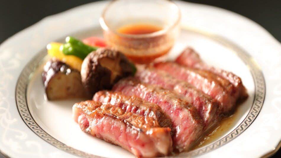 Echigo Inn Inamoto with sizzling steak served with colorful vegetables on a hot plate.