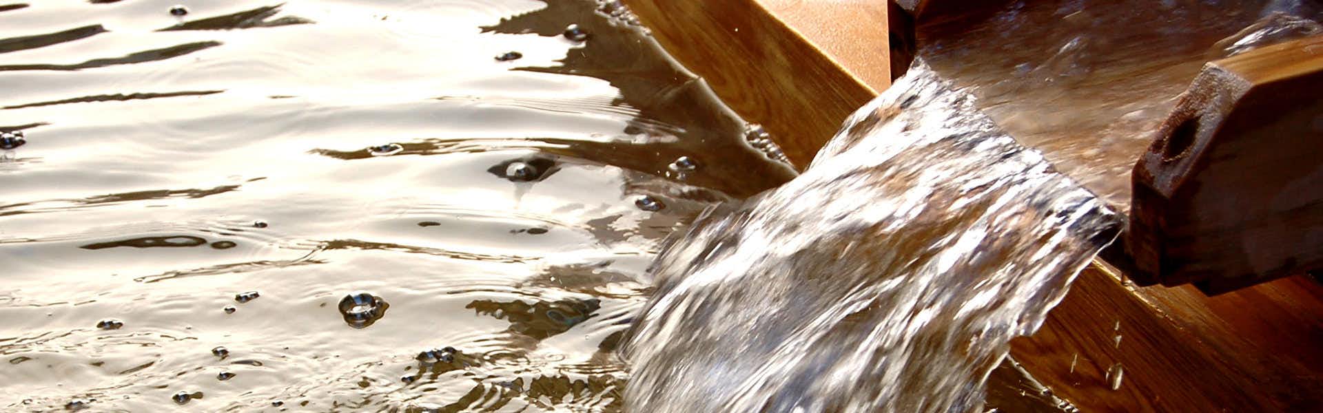 Arima Gyoen with mineral water spilling over the edge of a wooden bath.