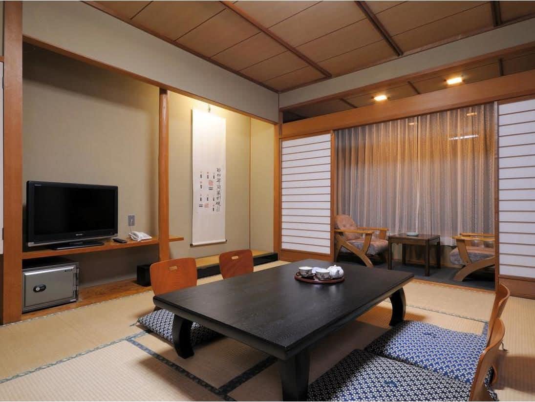 Miyajima Onsen Takinoso with this scene, where a second tatami room pairs a low black table with soft window light.