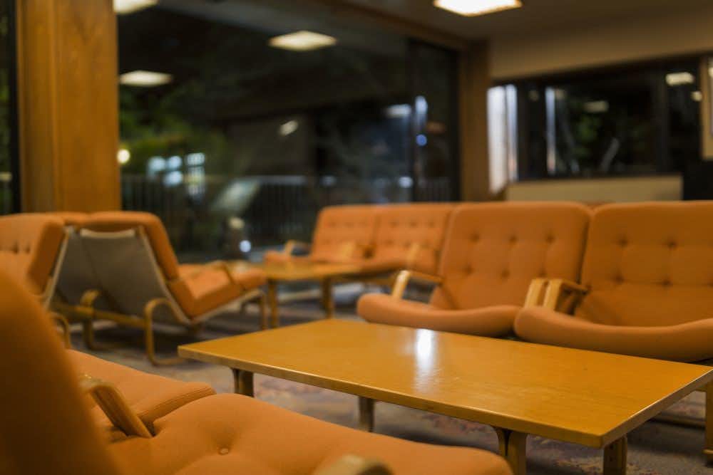 Minamitei with a comfortable lounge with orange sofas and timber tables.