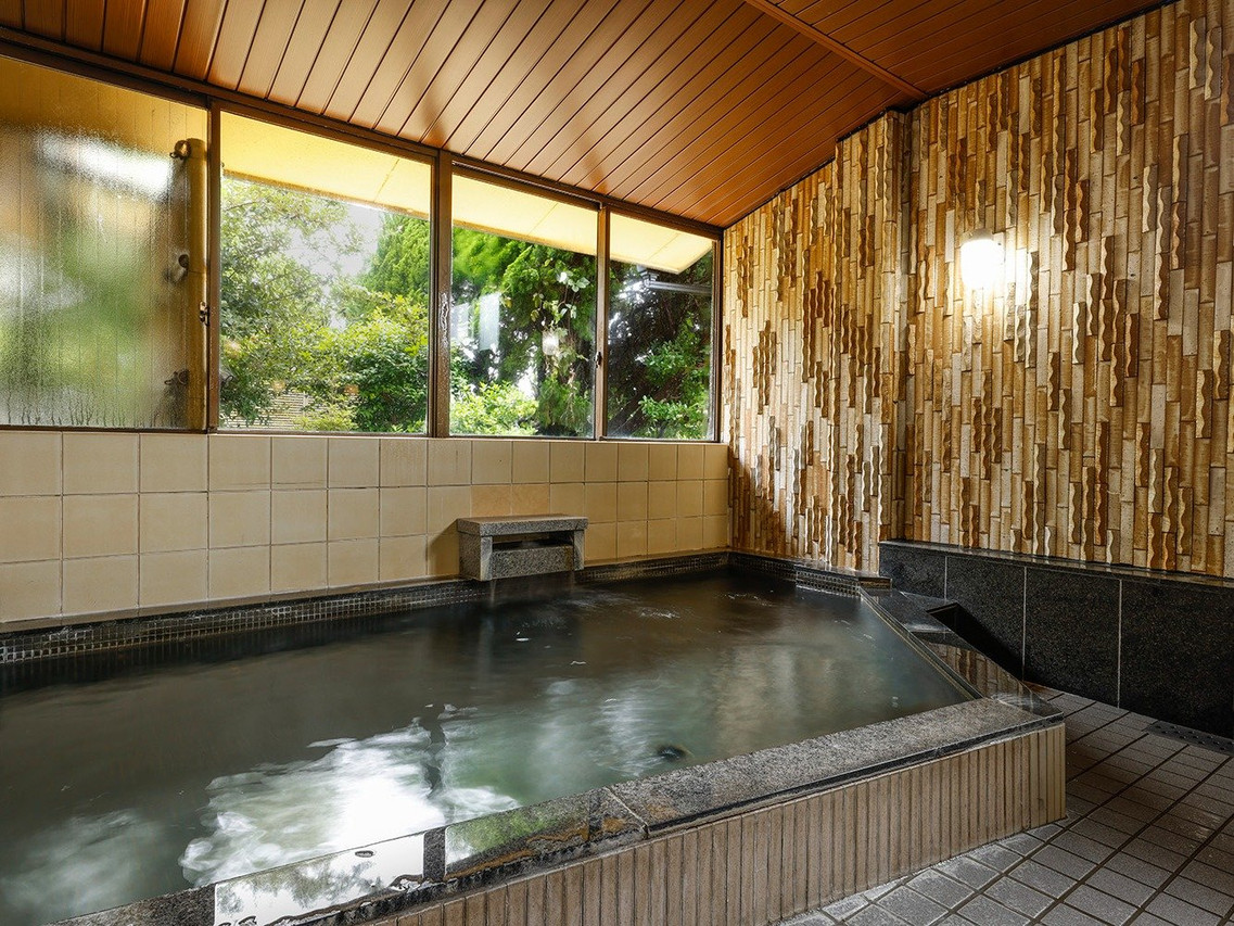 A tiled indoor bath with a window.