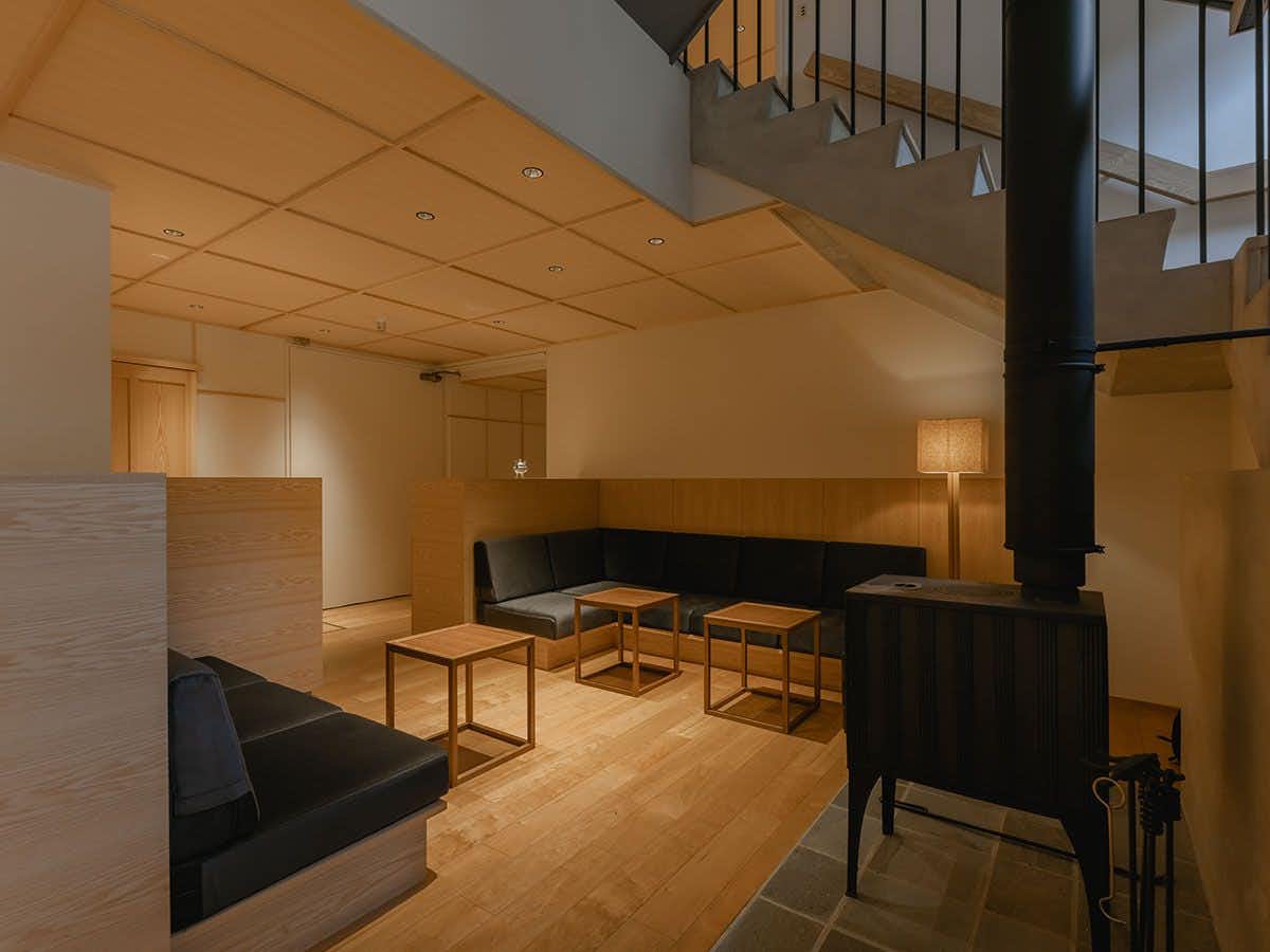 A modern lounge with black sofas and central fireplace.