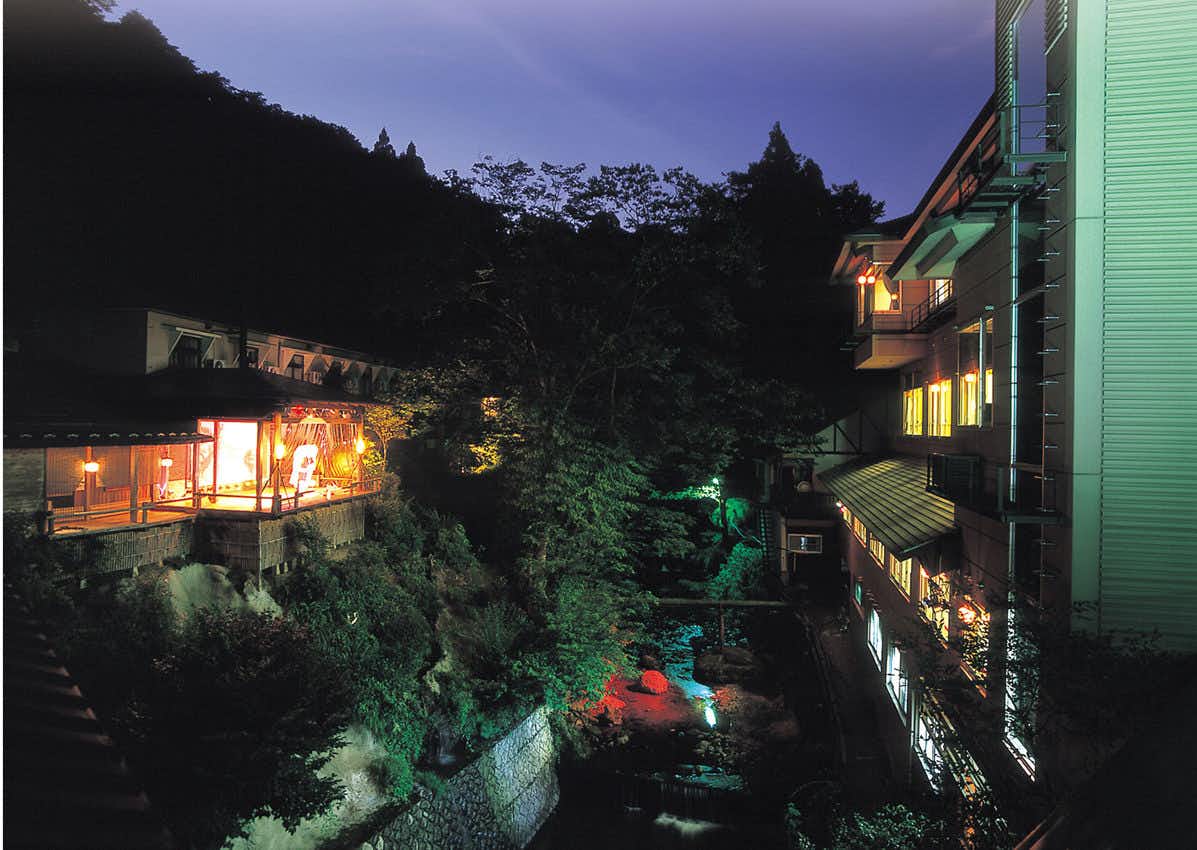 Hana no Yado Yomoyama-kan with this scene, where the inn glows along a wooded ravine after nightfall.