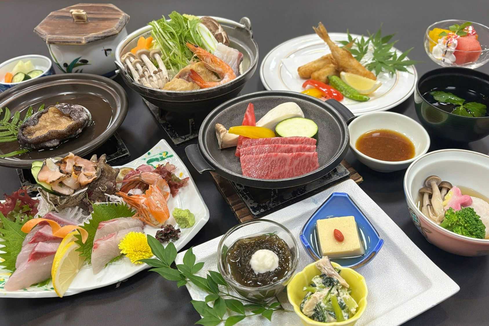 Ichinomata Onsen Kanko Hotel with a Japanese dinner combining sashimi, beef, and seasonal vegetables.