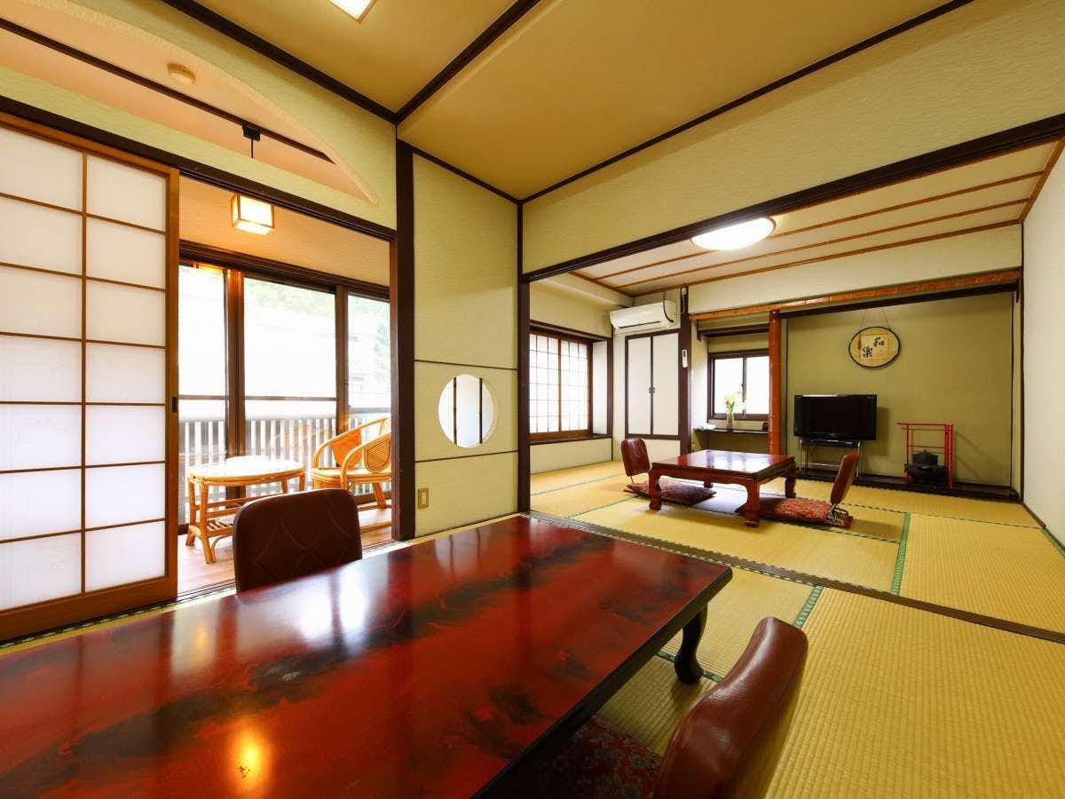 Ryokan Hakuunsou Dining area with long dark table, wooden chairs, tatami mat flooring, and paper screens with yellow ceiling beams.