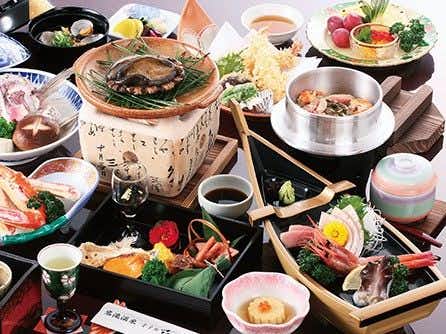 Iwataki Onsen Hotel Kirakuya with a Japanese dinner arranged across colorful bowls and plates.