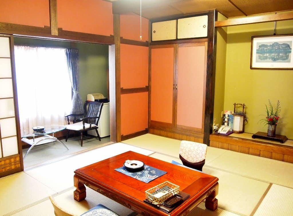 Central Hotel:Traditional Japanese style inn with a tatami room centered on a polished red table.