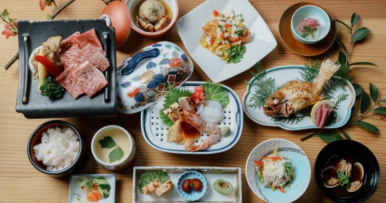 Iwami no Yu Mimata Onsen Nagomi Yuyado Kanagi with a Japanese dinner arranged across colorful ceramic dishes.