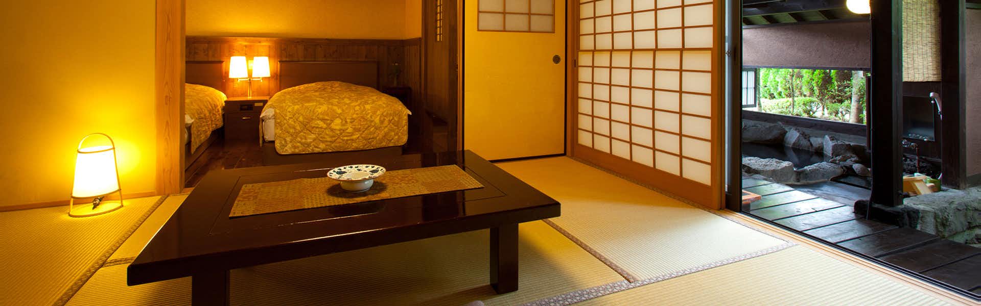Shugetsu with a warm tatami room with low table and amber bedside light.