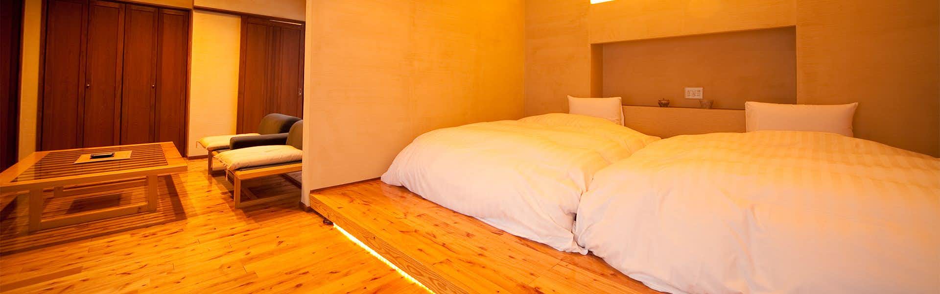Yufu no Yu YURI two large low beds in a warmly lit wood bedroom