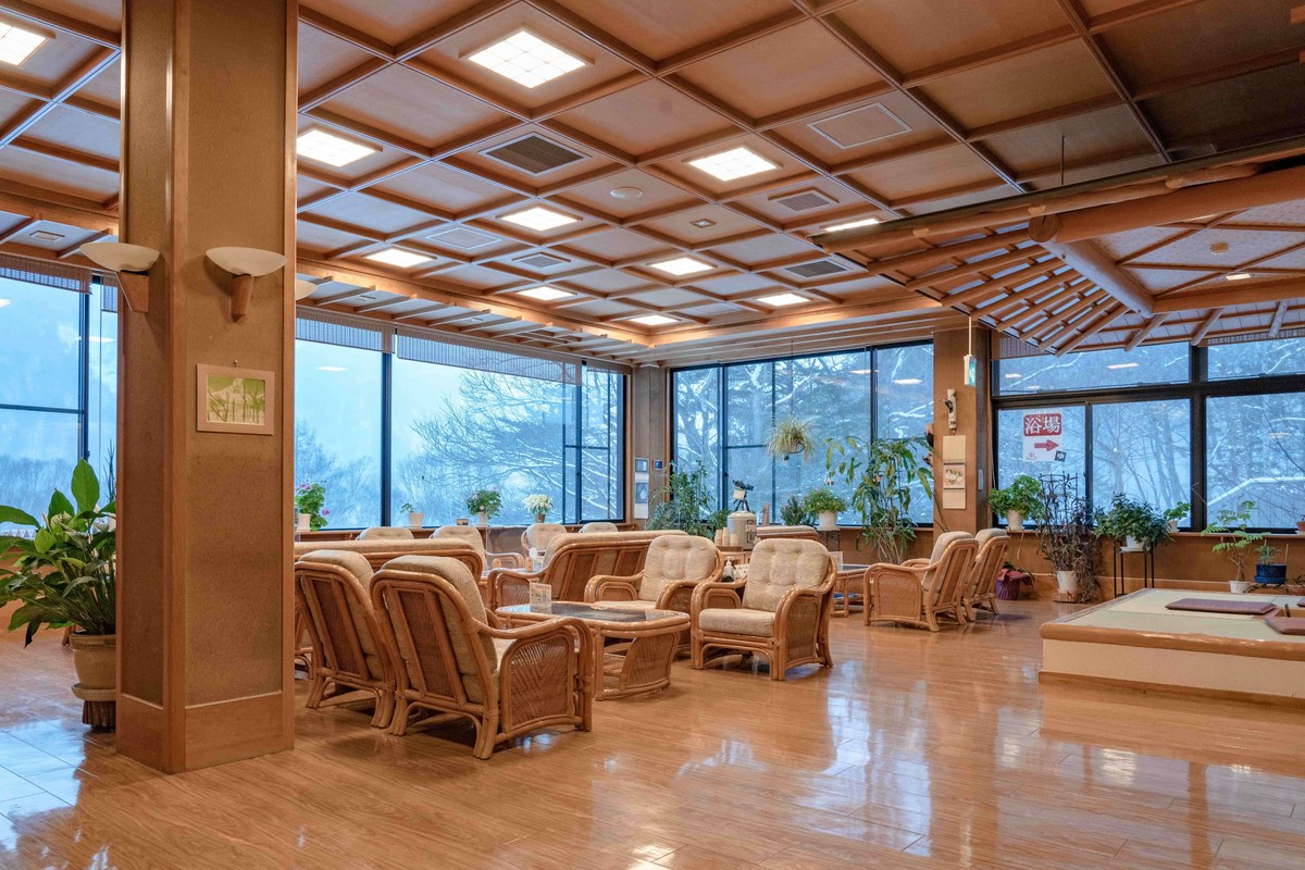 Nakanoyu Onsen Ryokan large lobby with wicker seating and broad windows