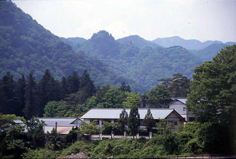 The hotel complex below steep wooded mountain ridges.