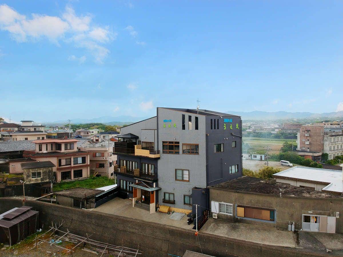 Shiosai no Yado Uehisa with this scene, where the inn stands among coastal buildings with sea and hills beyond.