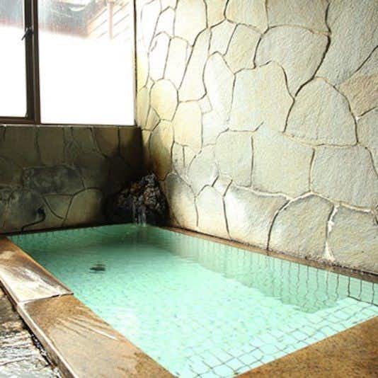 Takasekan with a private indoor bath filled with pale turquoise water.