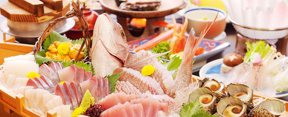Sashimi and seafood dishes spread across the table.