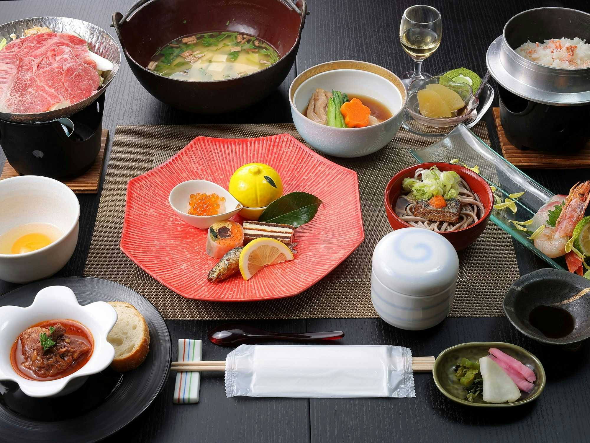 Warabe Uta no Yado Yunohara with this scene, where its dinner table pairs a tabletop pot with fish and small bowls.