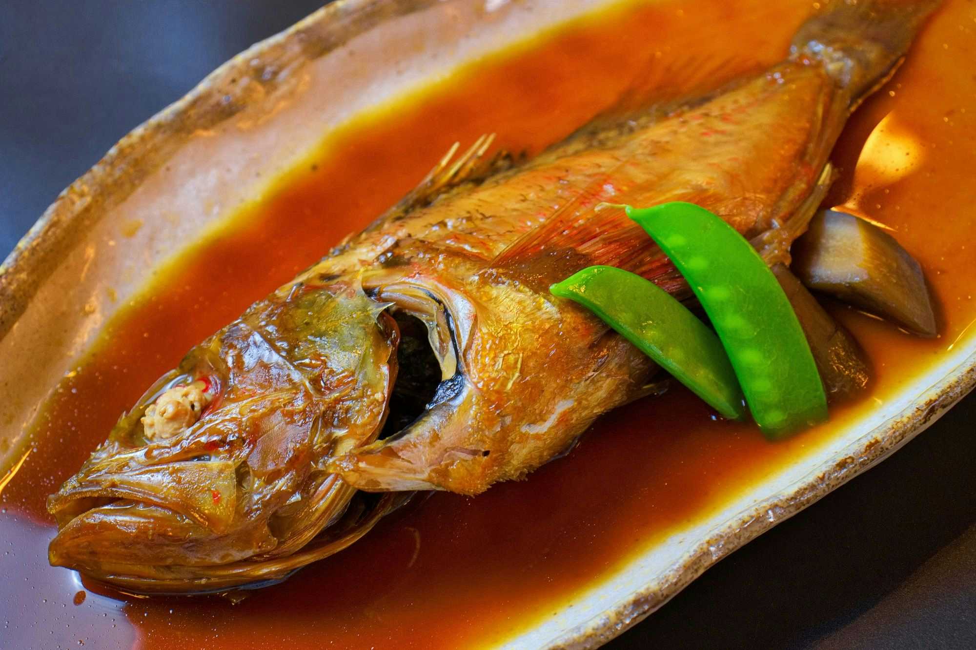 Gyogyosaisai Shunmi no Yado Uosho with a whole simmered fish garnished with green snow peas.
