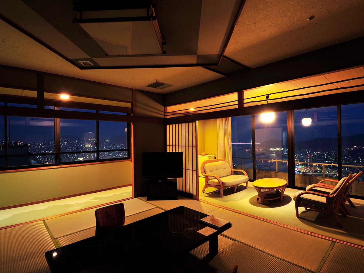 A tatami room overlooking Nagasaki at night.