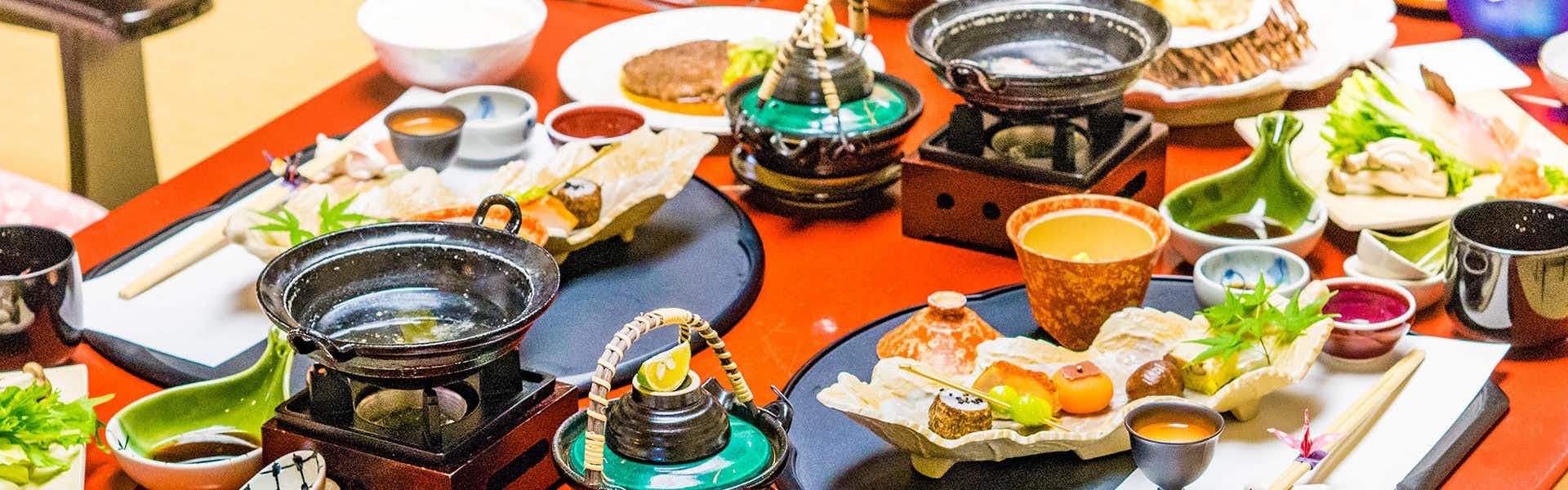 Nohanatei Komurasaki with a colorful kaiseki dinner arranged across lacquered trays.