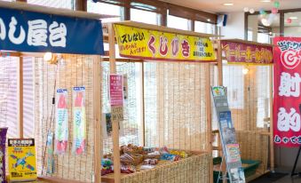 Indoor game stalls with colorful Japanese signs.