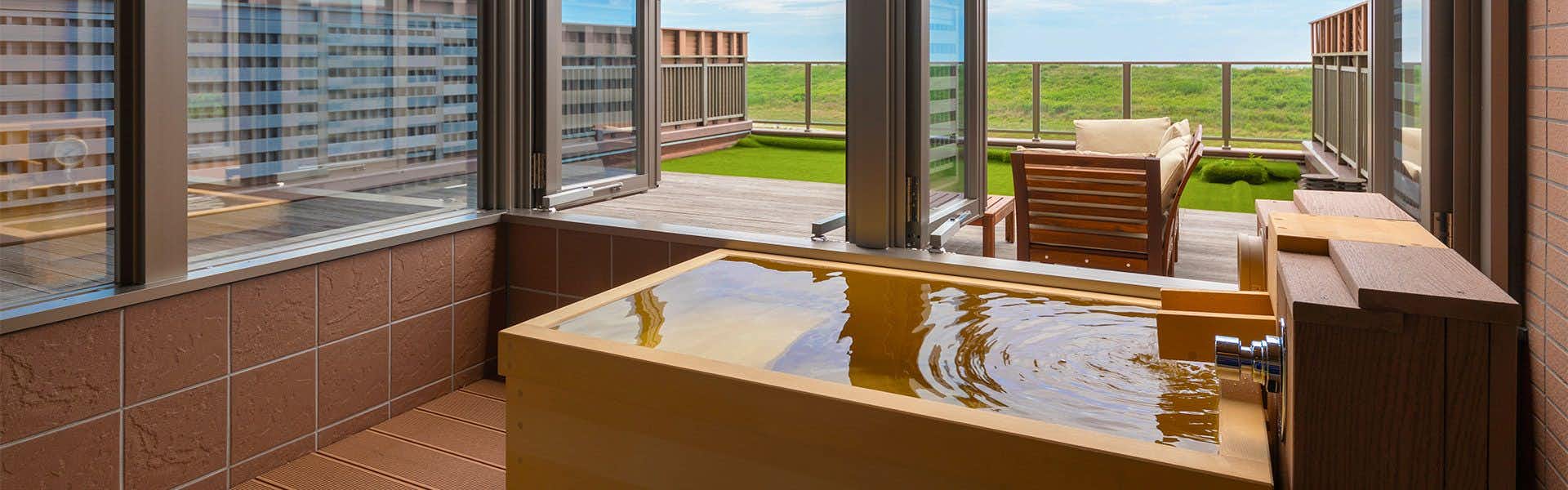 Watari Onsen Tori no Umi with a private soaking bath beside broad coastal windows.