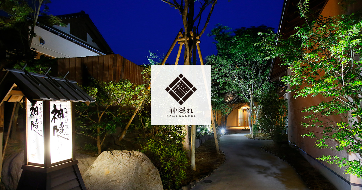 Lantern-lit entrance walkway among trees.