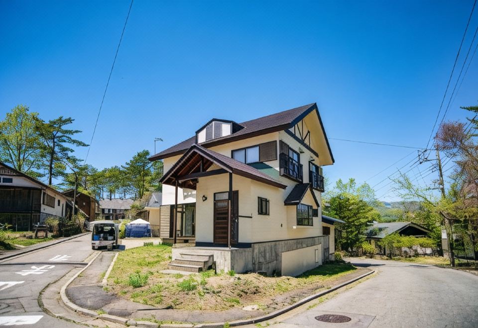 A small gabled lodging building beside a fork in the road.