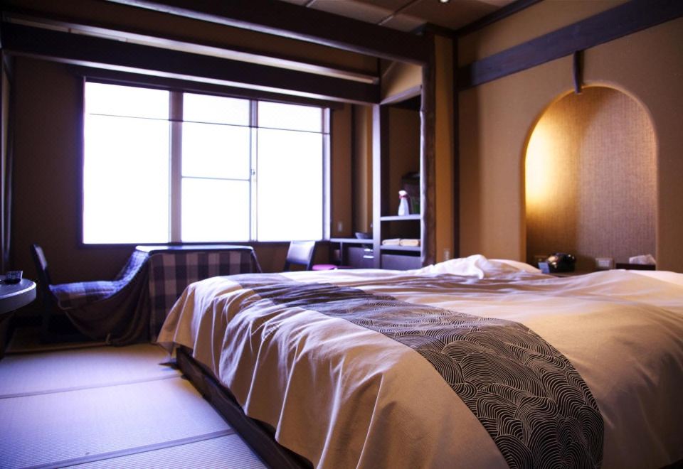 A Japanese guest room with a bed.
