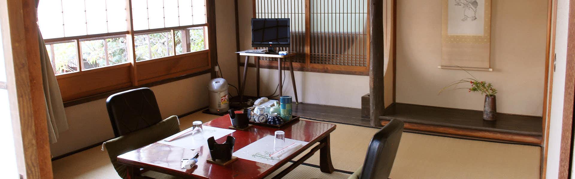 Garden Inn Bingoya with a guest room with twin chairs beside broad windows.
