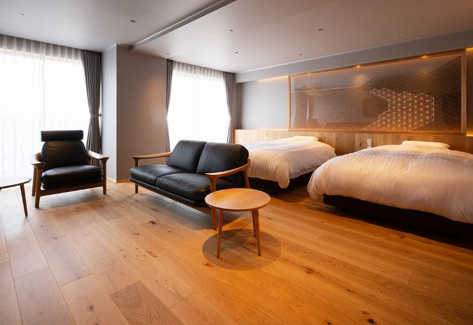 A modern twin room with a lounge area.