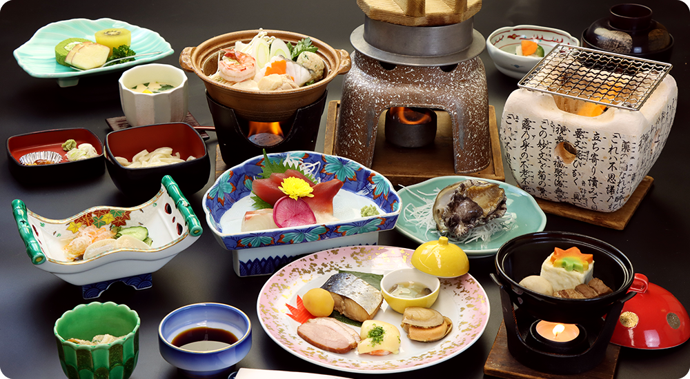 A colorful spread of small dishes is arranged around a central grill.