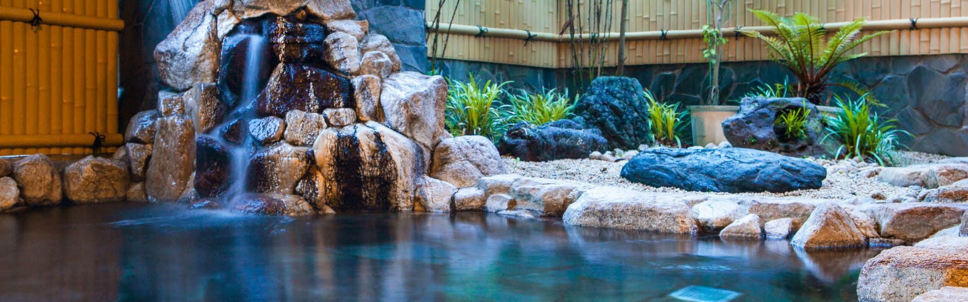 Sansuien, Natural Hot Spring at the Foot of Kochi Castle with an outdoor rock bath beside a landscaped waterfall.