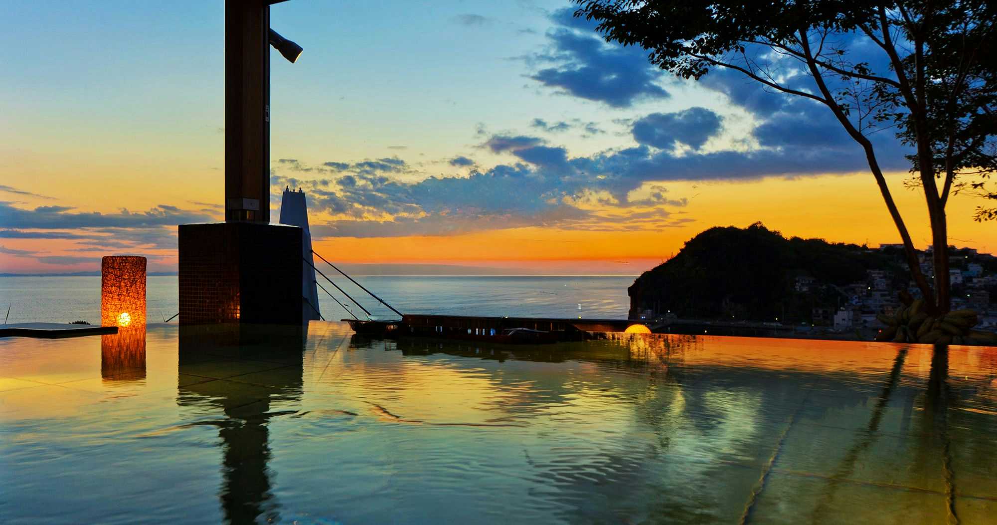 Kishu Onsen Arigatou no Yu, ISARIBI-NO-YADO Seaside KANCHO seaside outdoor bath beneath an orange sunset