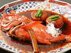 Yugawara Ohnoya Ryokan with a whole simmered fish presented on patterned ceramic tableware.