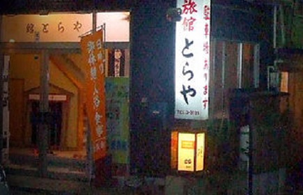 The ryokan entrance with illuminated Japanese signs.