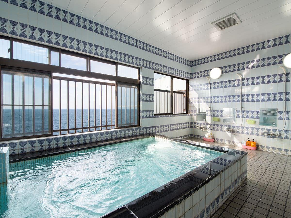 Ryokan Onishi with a blue-tiled indoor bath with broad street windows.