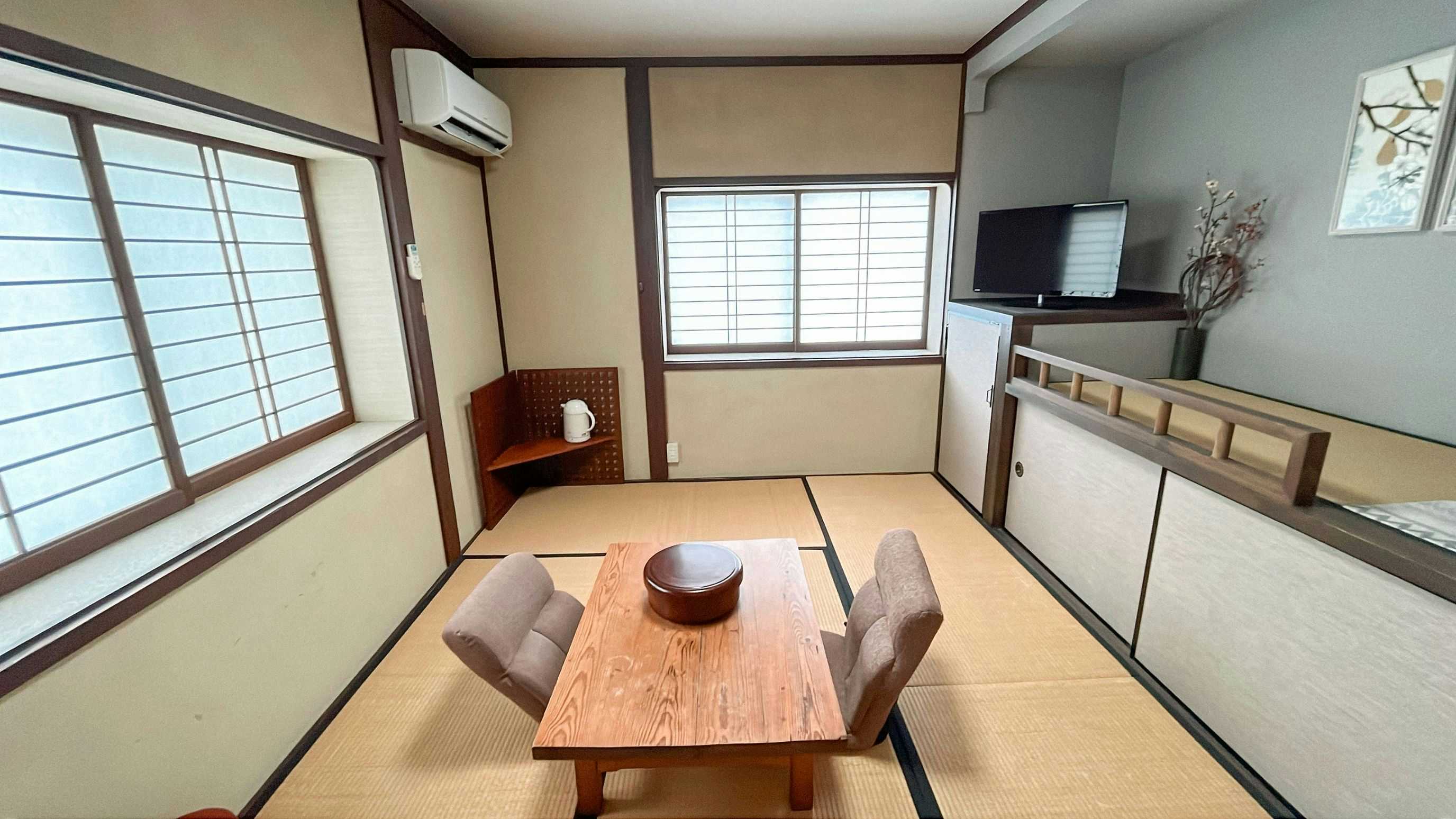 Chidori Ryokan with a bright tatami room with low table and broad windows.