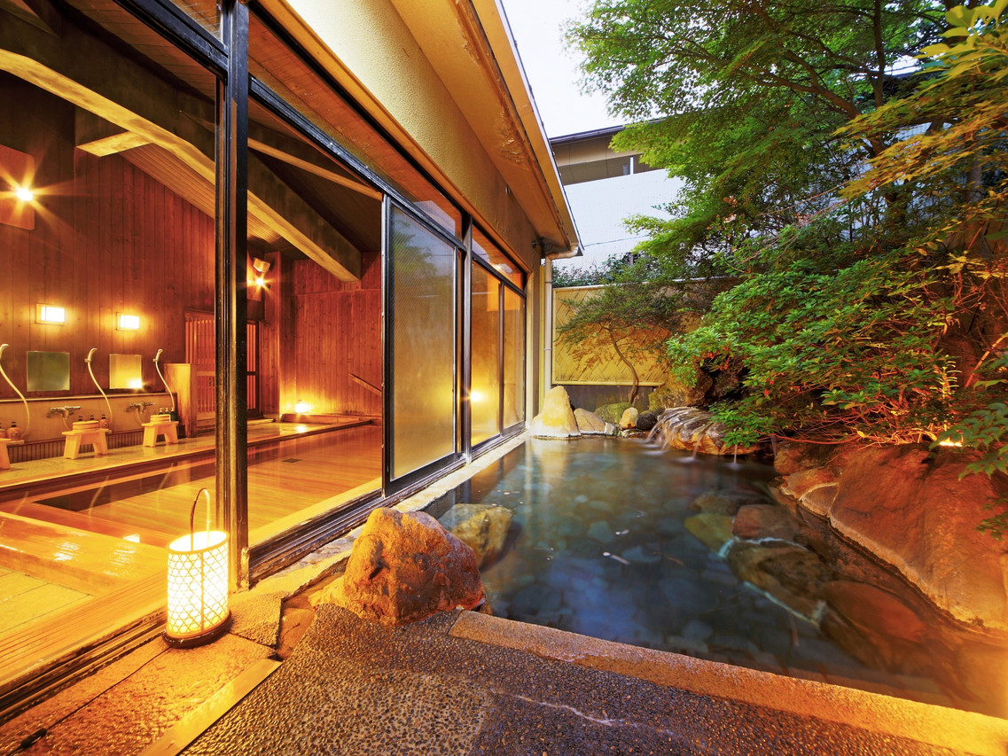 Wood-paneled bath beside a garden.