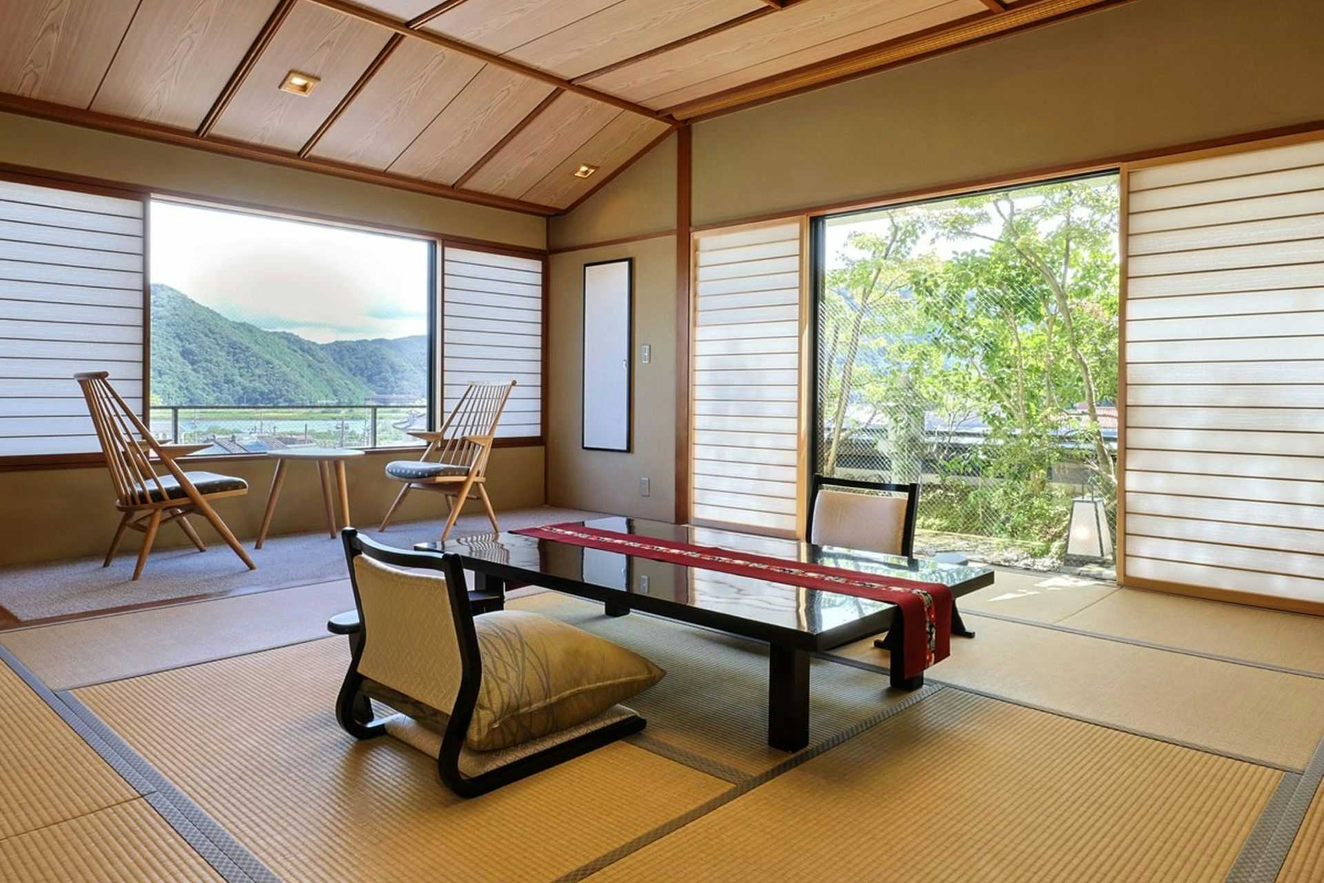 Kinosaki Ryokufukaku Tatami room with low wooden table, floor cushions, shoji screens, ceiling beams, mountain and vegetation view through windows